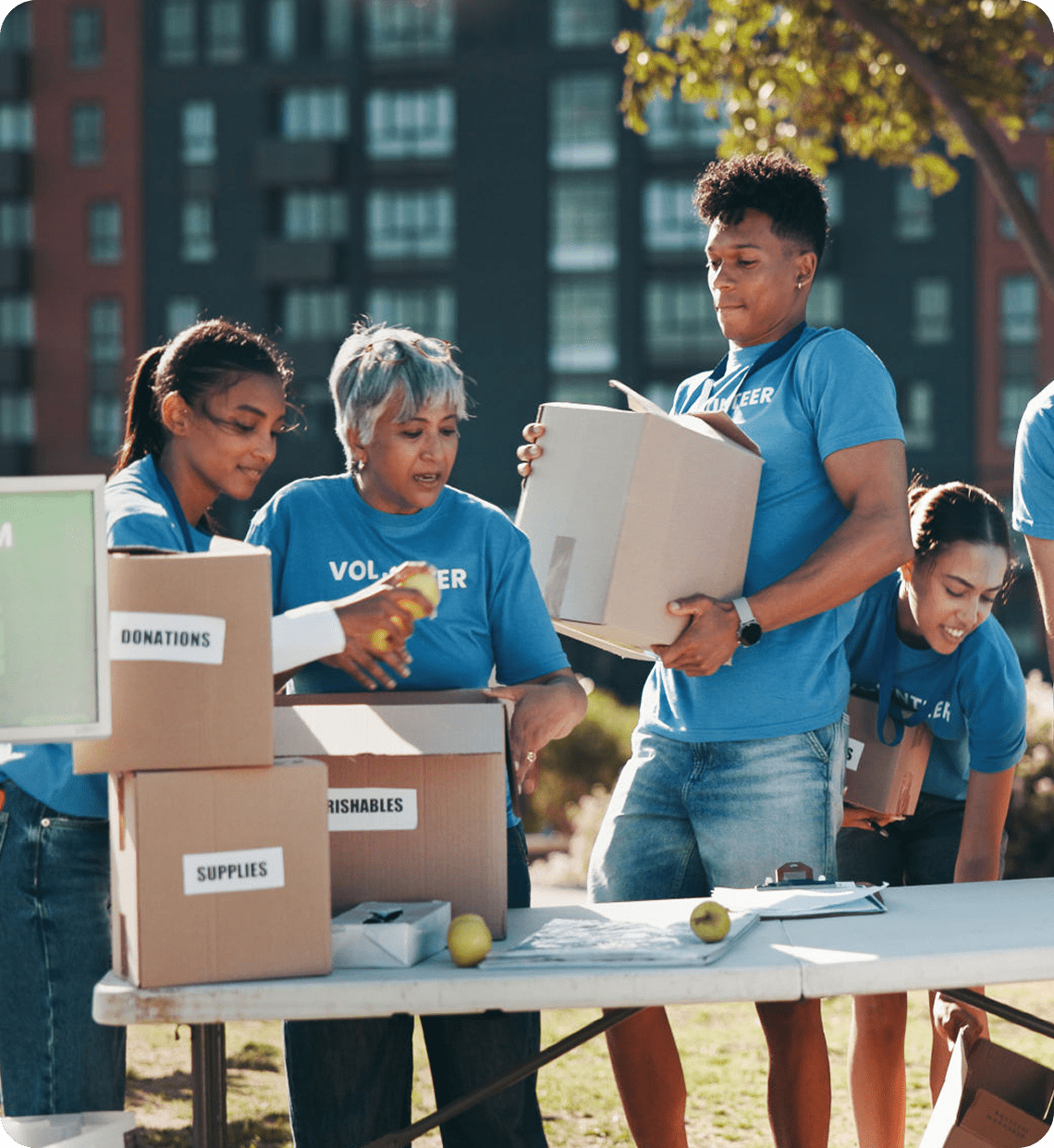 Volunteers organizing donations at outdoor event.